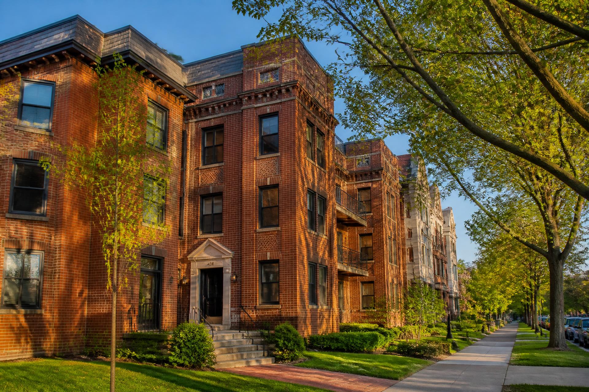 Restored brick apartment building on a tree-lined Central New York street